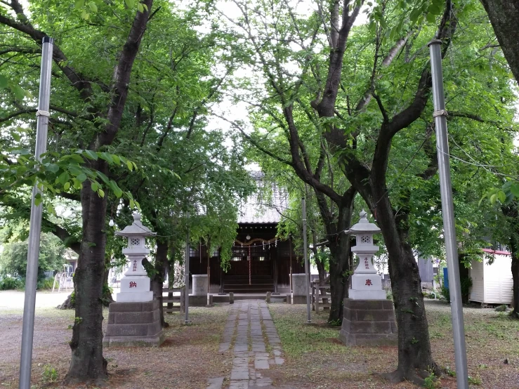 a stone pathway between two concrete poles and trees