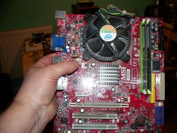 hand that is pointing to a computer motherboard