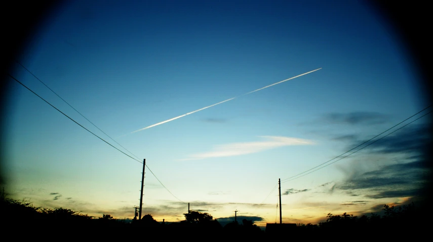 the view of sky with some contrails taken at dusk