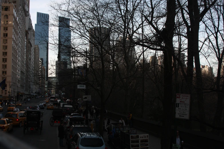 many people in cars and people walking on the street