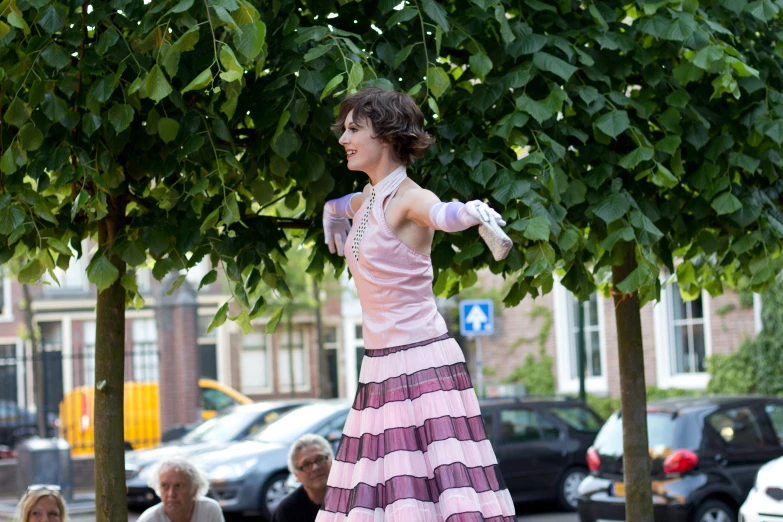 a woman wearing a striped skirt walking next to trees