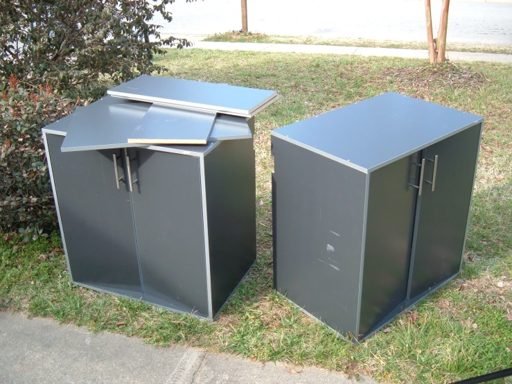 the metal trash cans sit in the grass