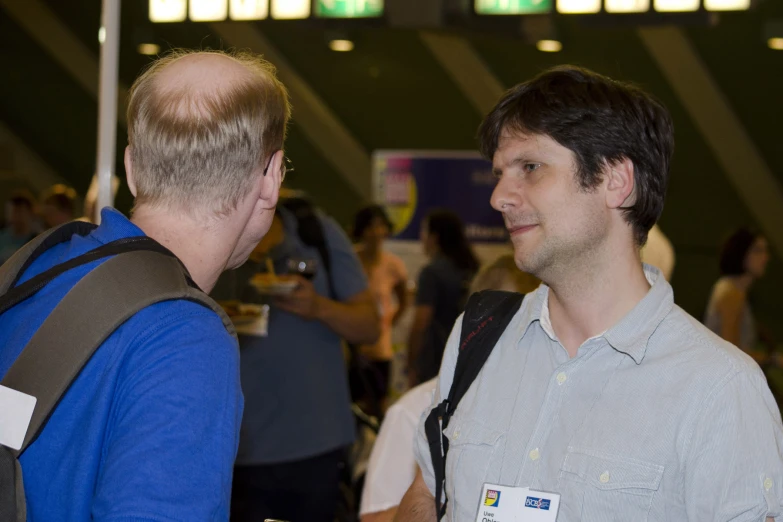 two men are talking while standing together