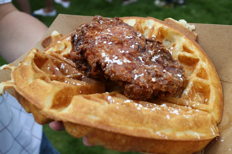 a fried chicken and waffle sandwich in a paper bag