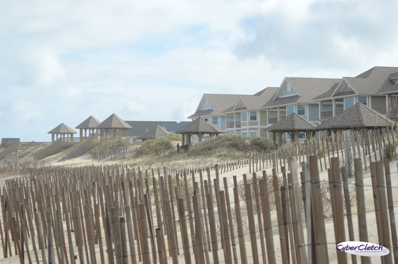 houses on the beach behind fence made of wood