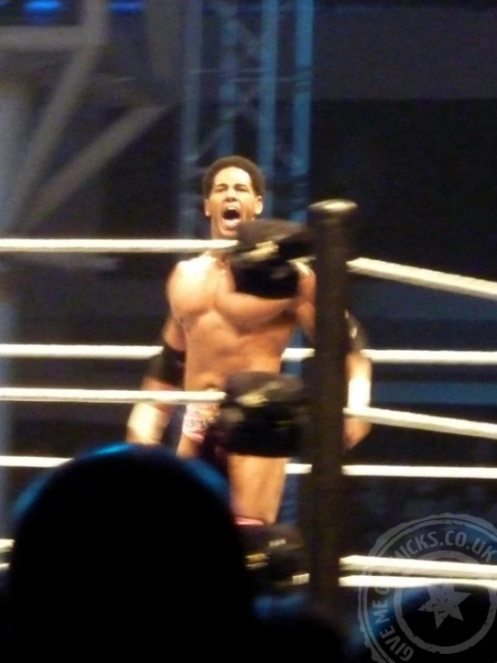 a shirtless man is standing on top of a boxing ring