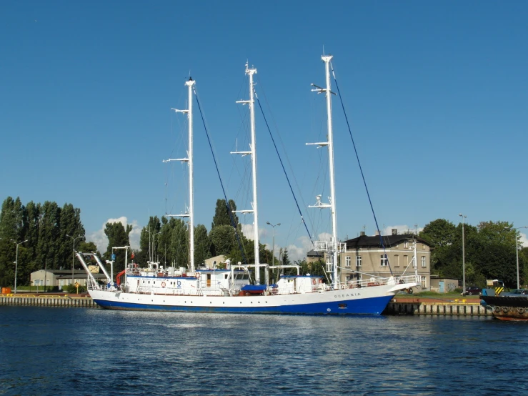 a very pretty blue and white boat by the water