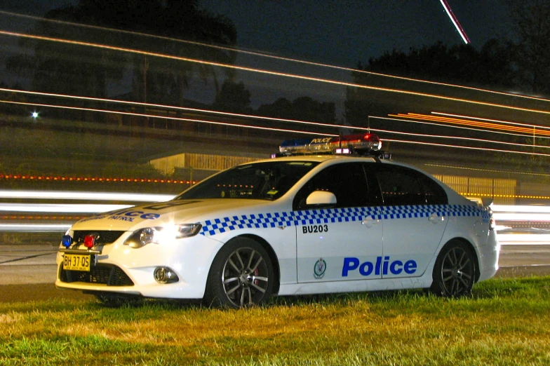an police car parked in the grass near a field