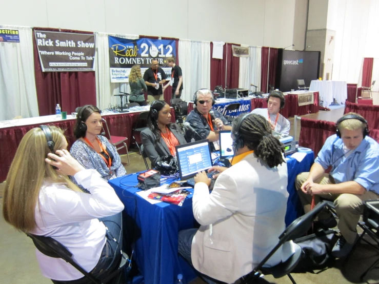 several people seated at a table with laptops