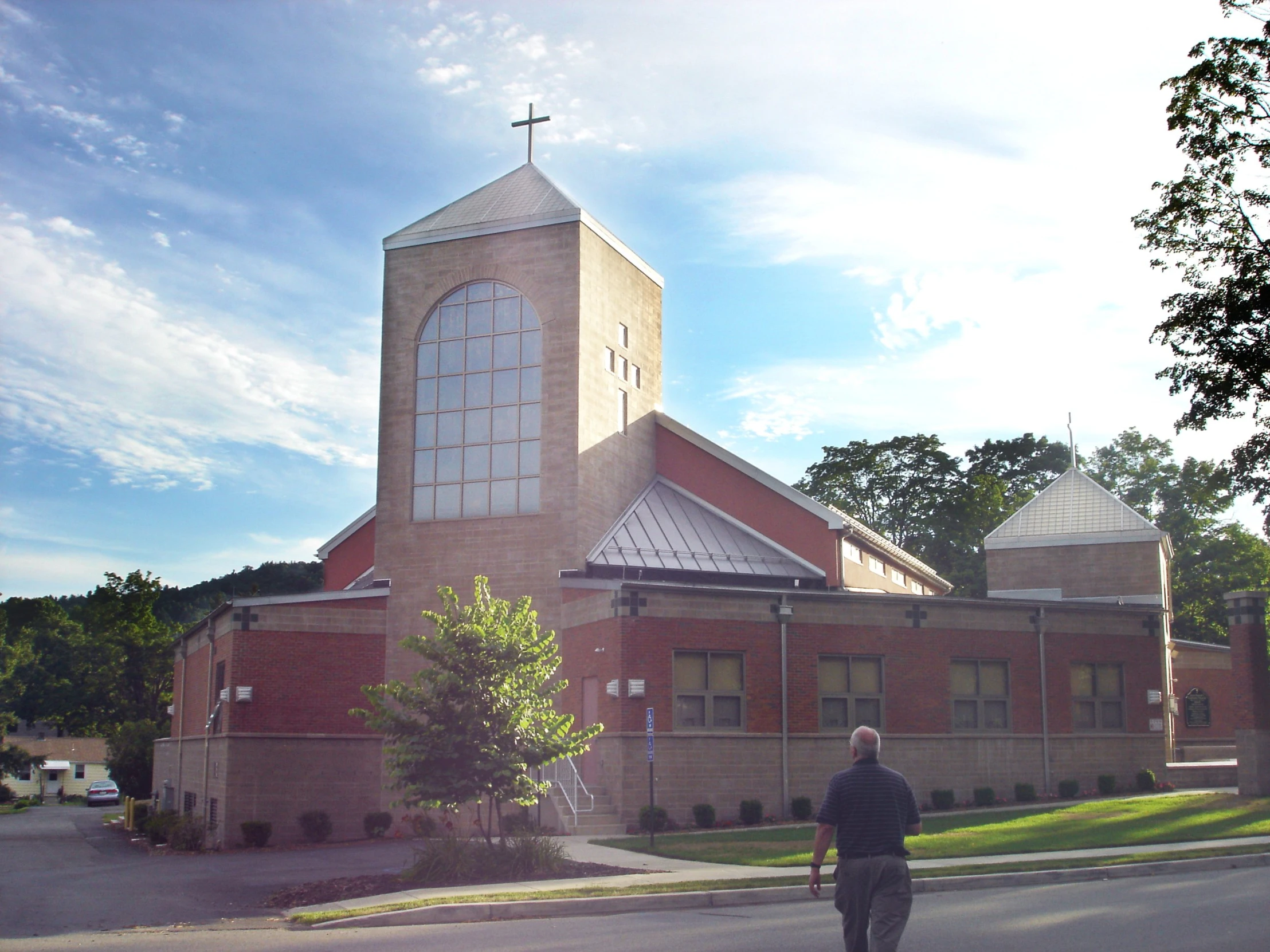 a person walking in the road past a brick building