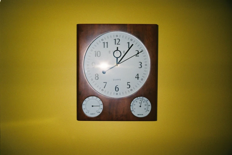 clock with four different dials on yellow wall