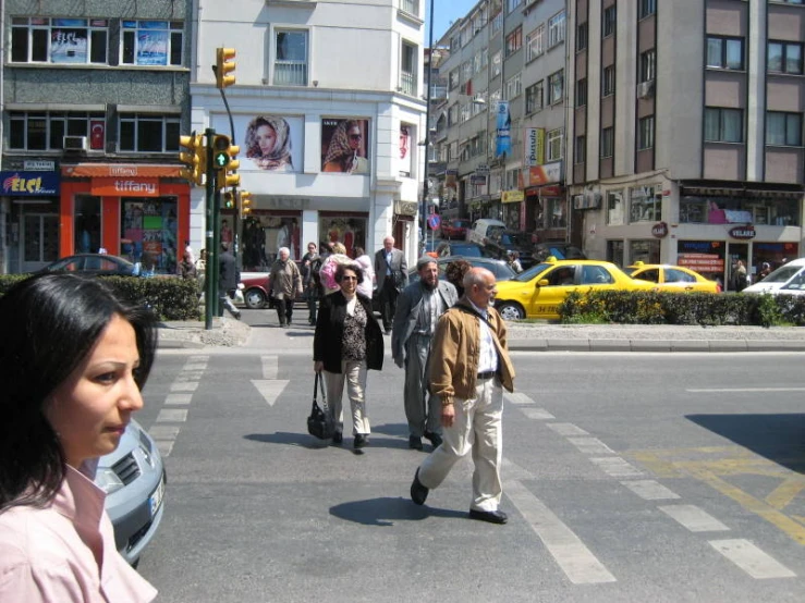 several people walk along the busy street in a large city