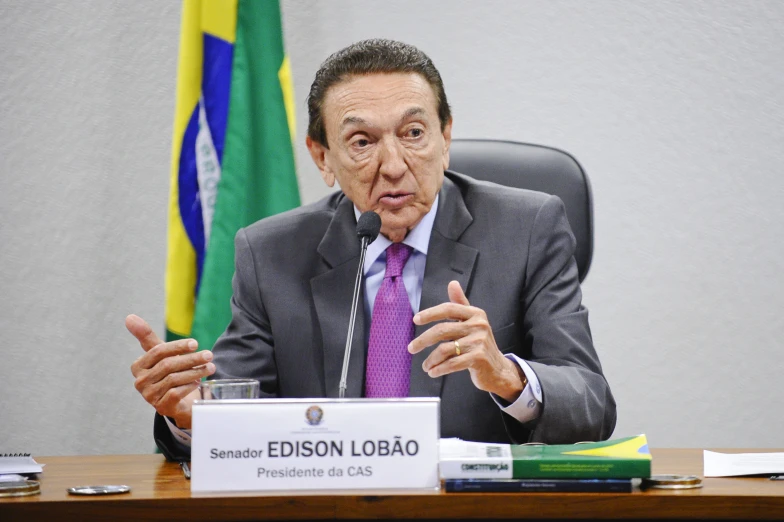 a man sitting at a table in front of flags