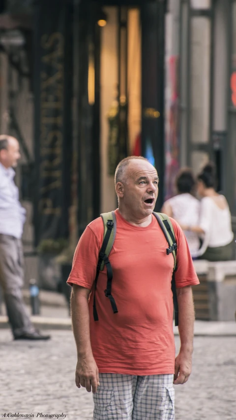 a man is making faces while walking on the sidewalk