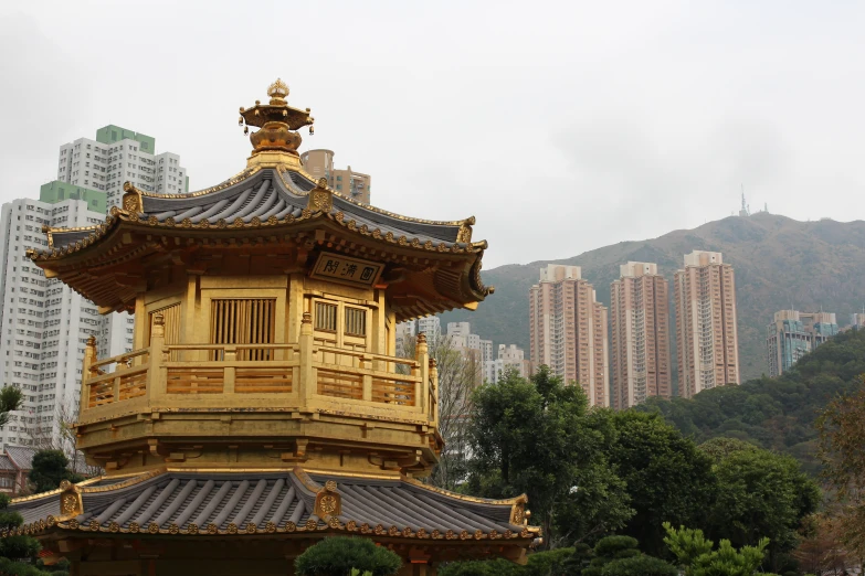 a golden pavilion sits in front of some buildings