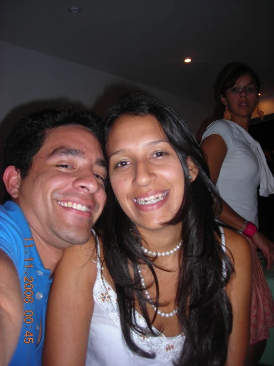 two people smile while posing for the camera