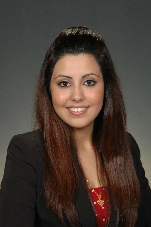 a woman with long hair wearing a black jacket and a red top