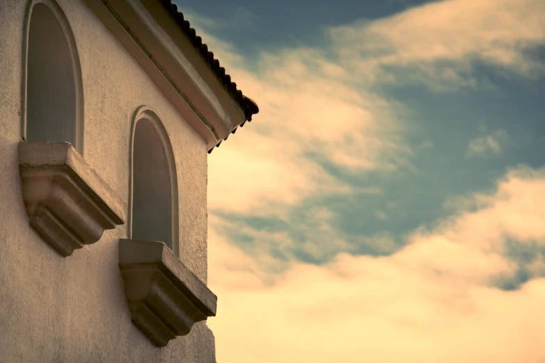 the sky over some small white houses with arched windows