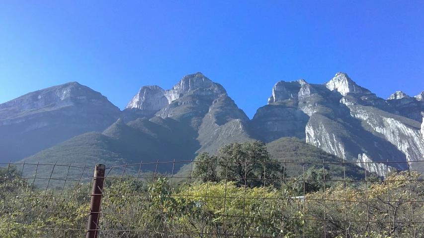 several mountains on both sides of a fenced in area