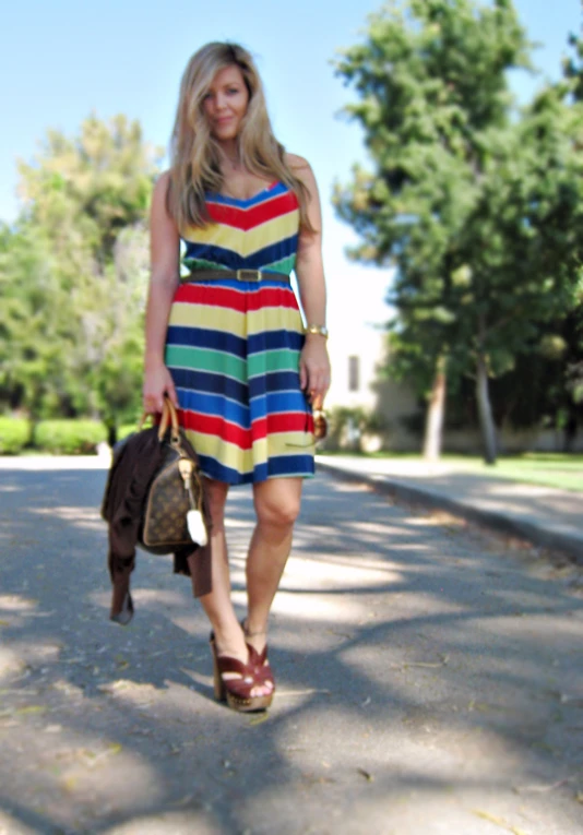 woman in colorful dress on roadway with purse