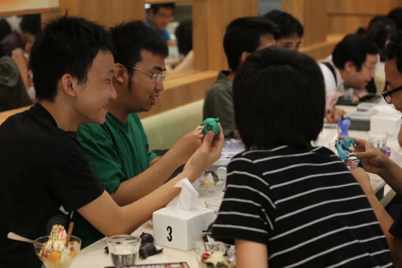 some people sitting at a table with plates and trays of food