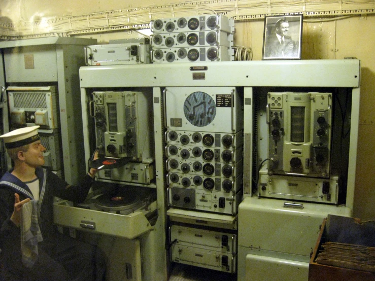 a man standing in front of a machine filled with mechanical equipment