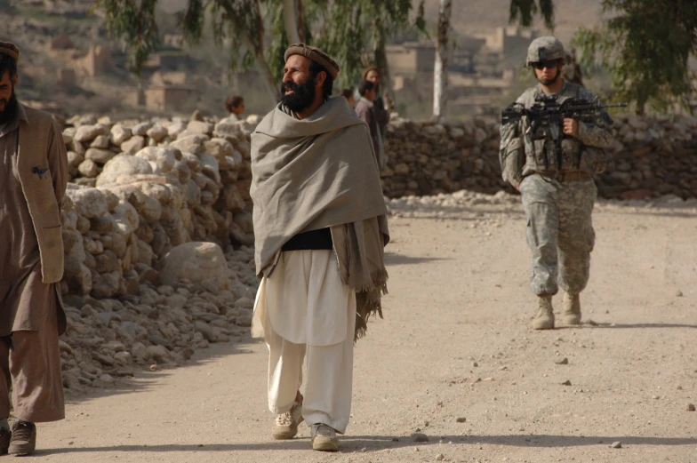 two soldiers with a group of people walking beside them