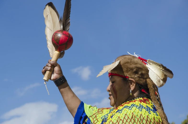 a person with a feather and ball on a sunny day