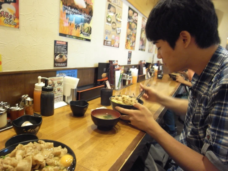 a man eating food at a table with a bowl