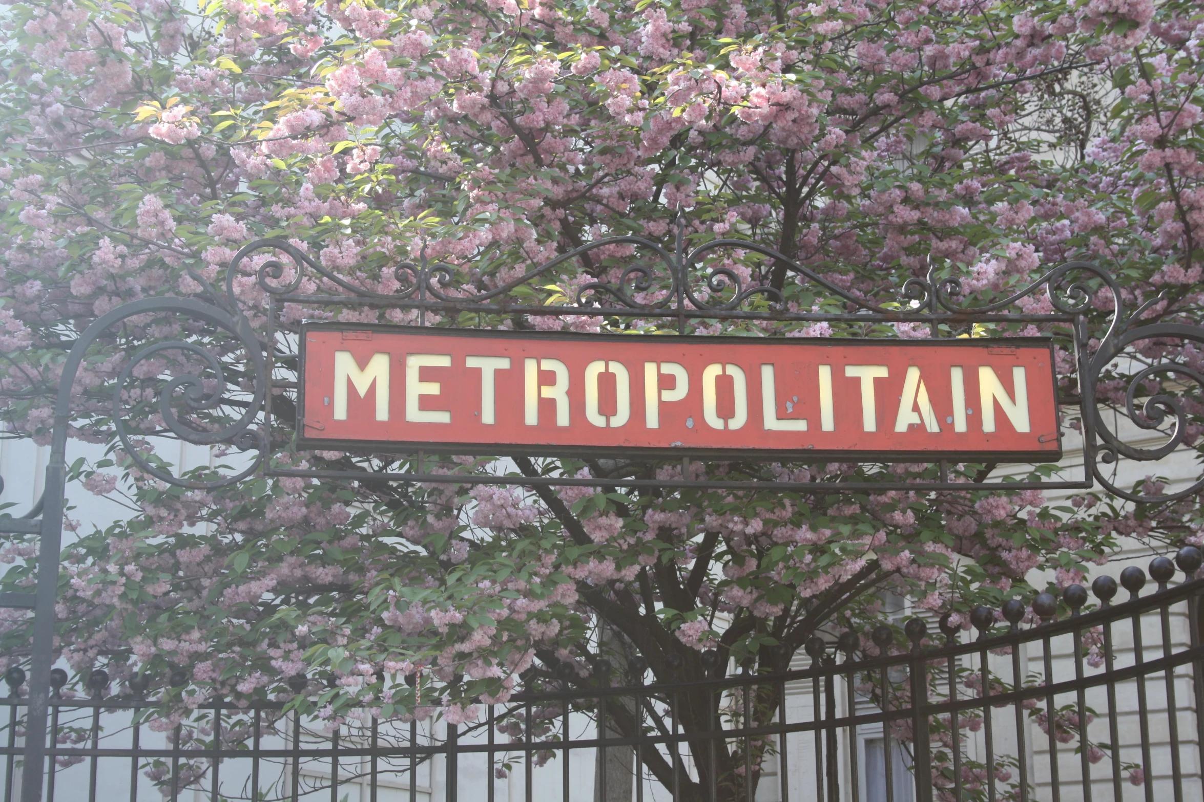 a red sign is mounted above a gate