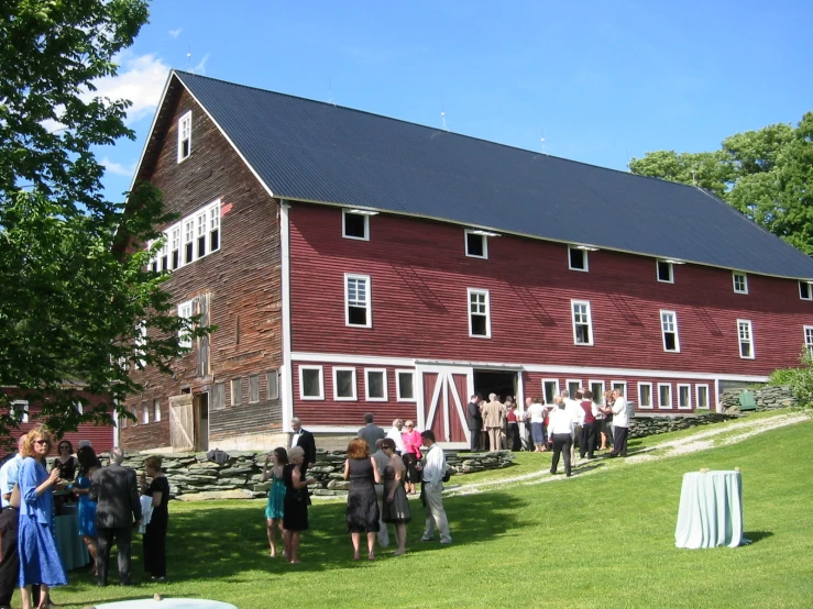 a group of people walking in front of a large red building