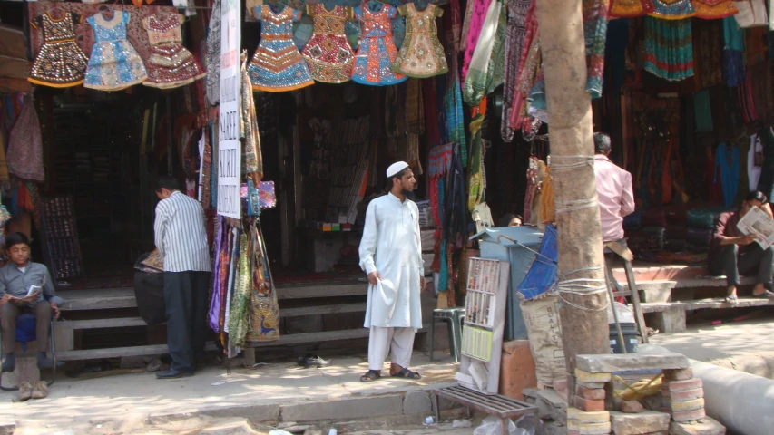 a man standing outside a shop selling traditional goods