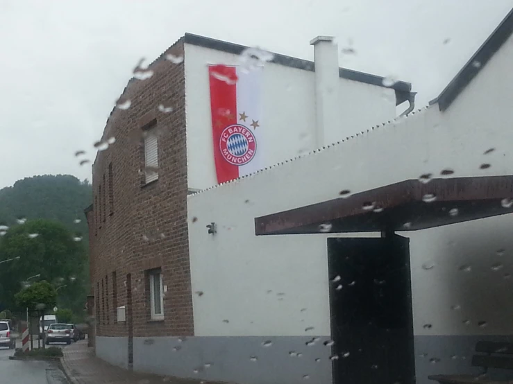 rainy windows outside an old building with two flags