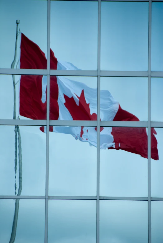 a canadian flag reflected in a glass window