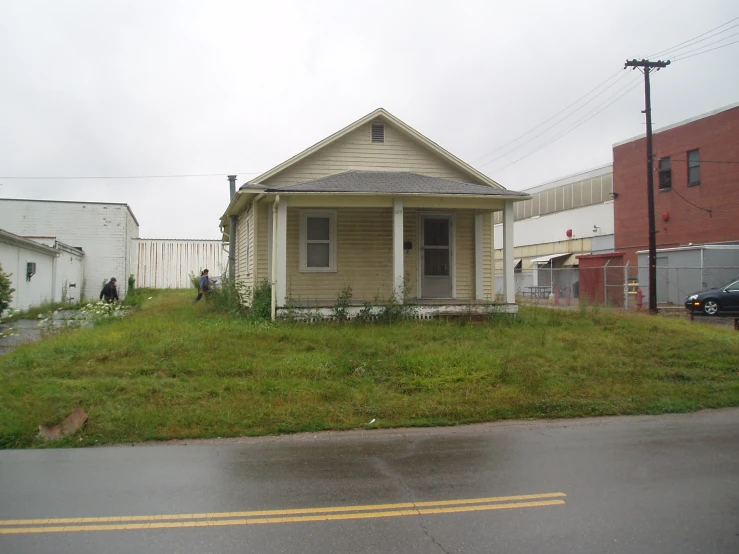 the small yellow building is near a fence and grassy area