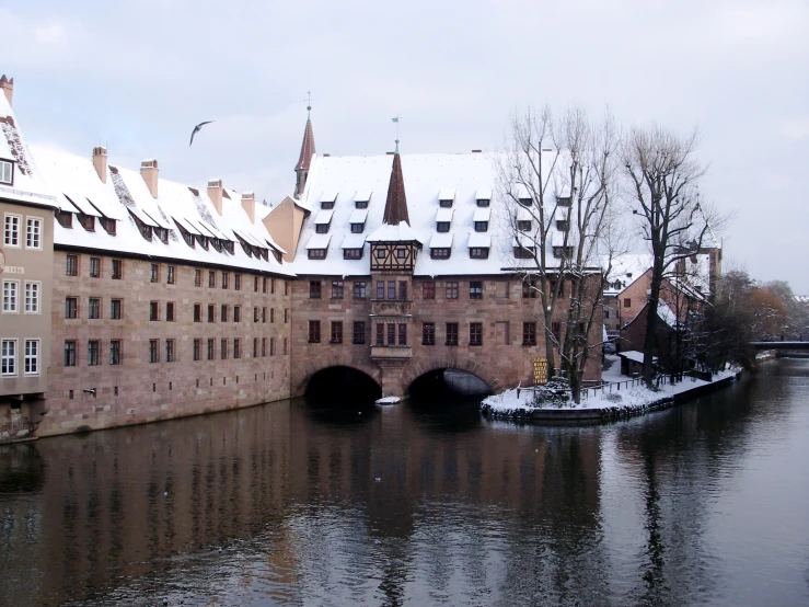 old buildings are located along the river on a cloudy day