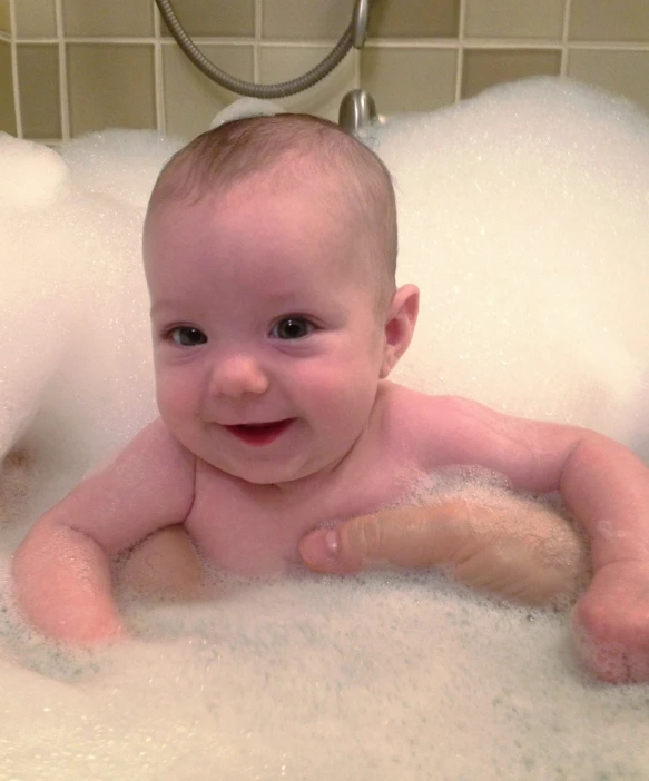 a young child in a bathtub with bubbles
