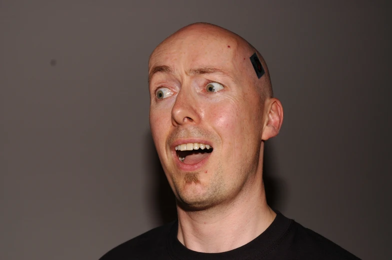 a bald man with a funny expression on his face