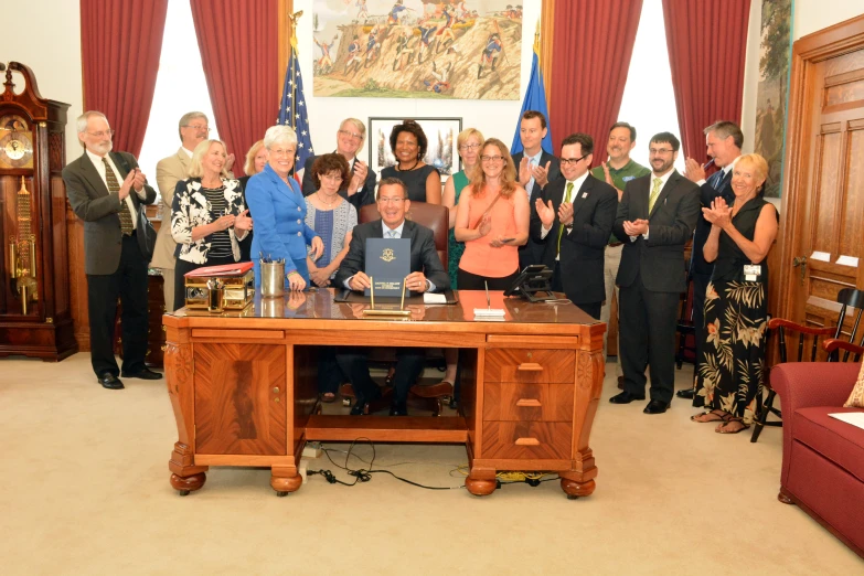 a group of people standing and sitting around a table