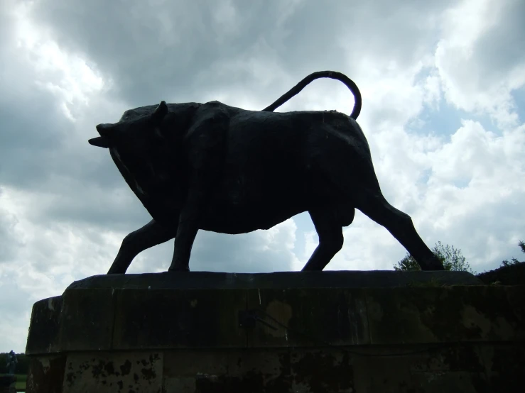 a statue of a bull is walking on top of a block