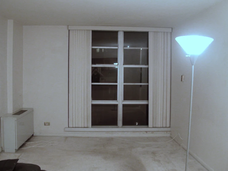 a room with white walls and windows has a light