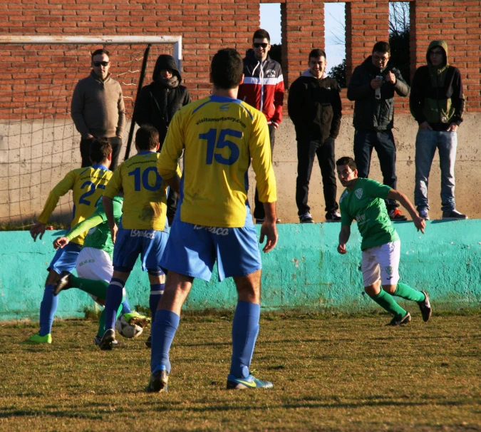 a group of men are playing soccer in front of a crowd