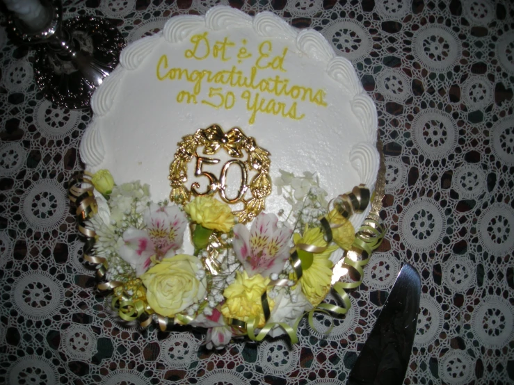 a cake with flowers and an anniversary number on top