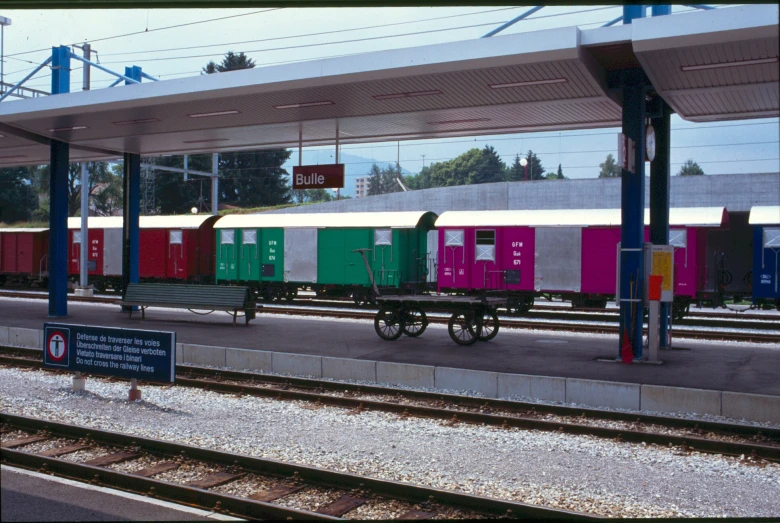 train carts with colorful sides pulled out at station