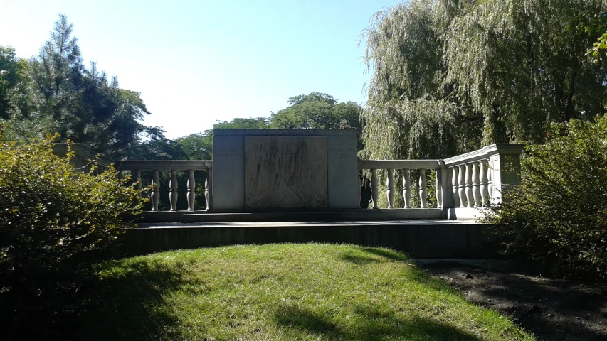 a bench with a memorial outside next to some trees