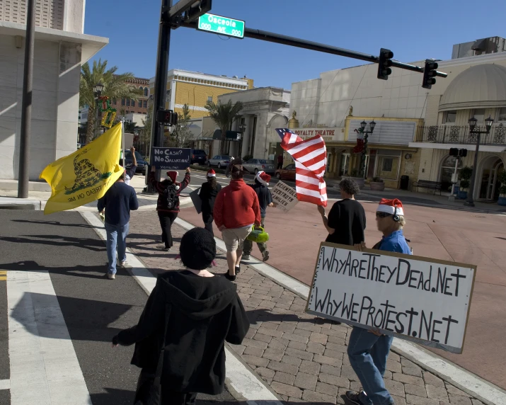 a group of protesters walk across a street