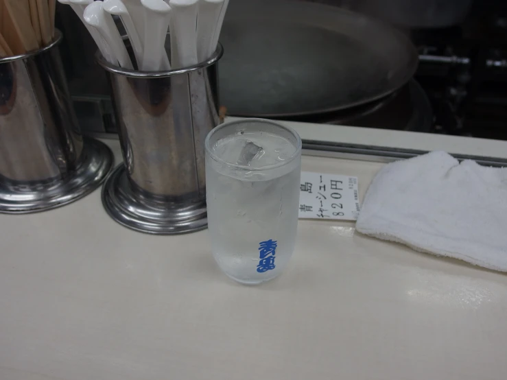 the glass next to the metal containers is full of water