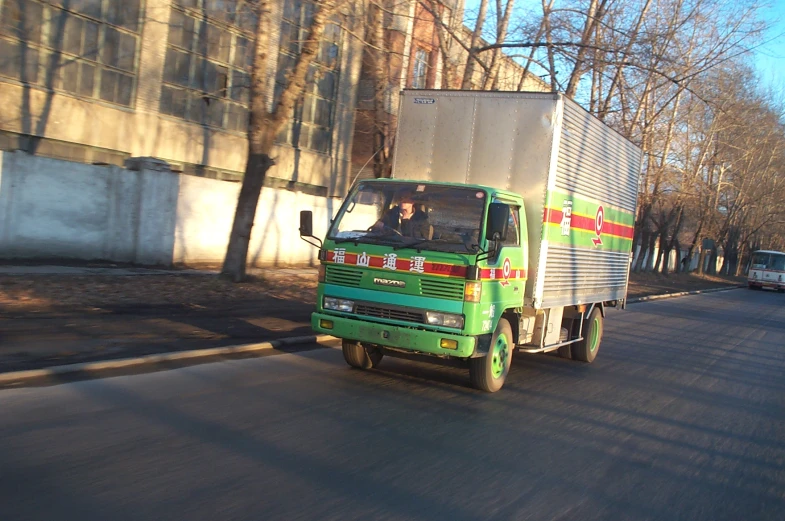 a large semi truck driving down the street next to another car