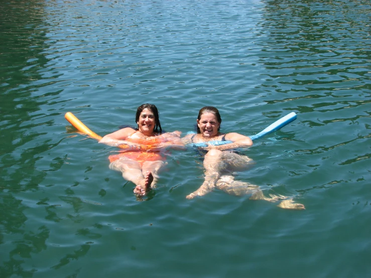 two women are sitting down with their boogie boards