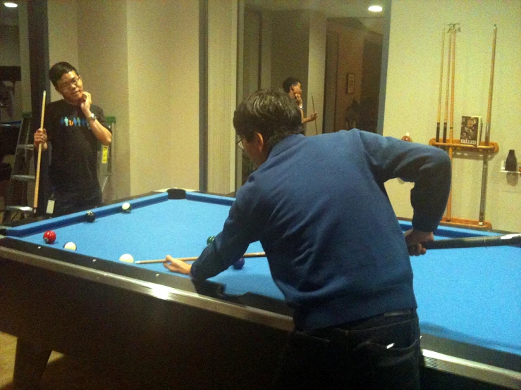 a man is holding a ball to make his racket hit a cue